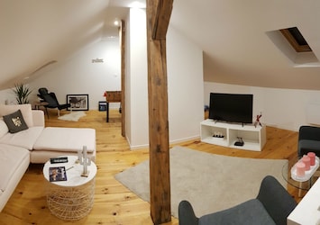 Bel espace sous comble avec chaise massante, jeux, télé et salon relaxant