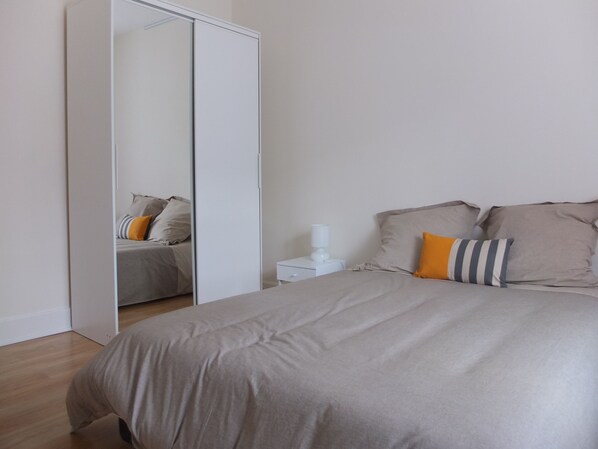 A bedroom with a bed, a nightstand, a bedside table, and a wardrobe. - T3 duplex in castle in Sologne (Neuvy-Sur-Barangeon)