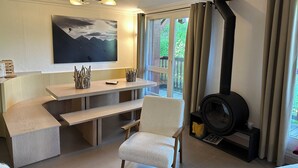 A cozy living area with a fireplace, a dining table, and a comfortable chair. - Arcs 2000, new 95m² apartment in a chalet, 2 min from the slopes, wifi, pkg (Bourg-Saint-Maurice)