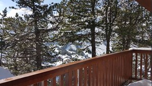 A wooden deck with a view of snow-covered trees and houses in the background. - Arcs 2000, new 95m² apartment in a chalet, 2 min from the slopes, wifi, pkg (Bourg-Saint-Maurice)