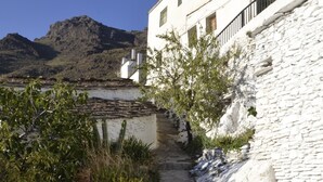 Un camí de pedra que condueix a un edifici blanc amb una escala.