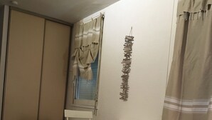 Quarto compacto com escrivaninha, cadeira e guarda-roupa.