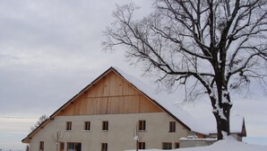 Un edificio amplio de una sola planta con techo inclinado, rodeado de nieve.