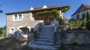 A stone house with a stone staircase leading to a porch. - Character house in the countryside. (Les Arques)