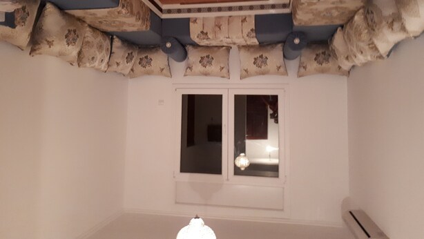 A room with a wooden ceiling, a window with a view, and a white wall. - Air-conditioned apartment saidia (Saïdia)