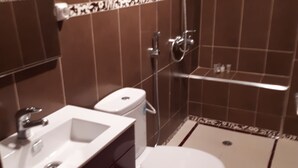 A modern bathroom with a black and white tiled floor, a white sink, and a red towel. - Air-conditioned apartment saidia (Saïdia)