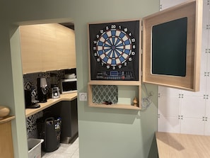 Dartskive monteret på en væg med et træskab nedenunder.
