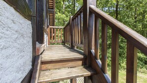 A wooden staircase with a railing leading to a higher level, surrounded by greenery. - Studio in a park near Chambord (ST LAURENT NOUAN)