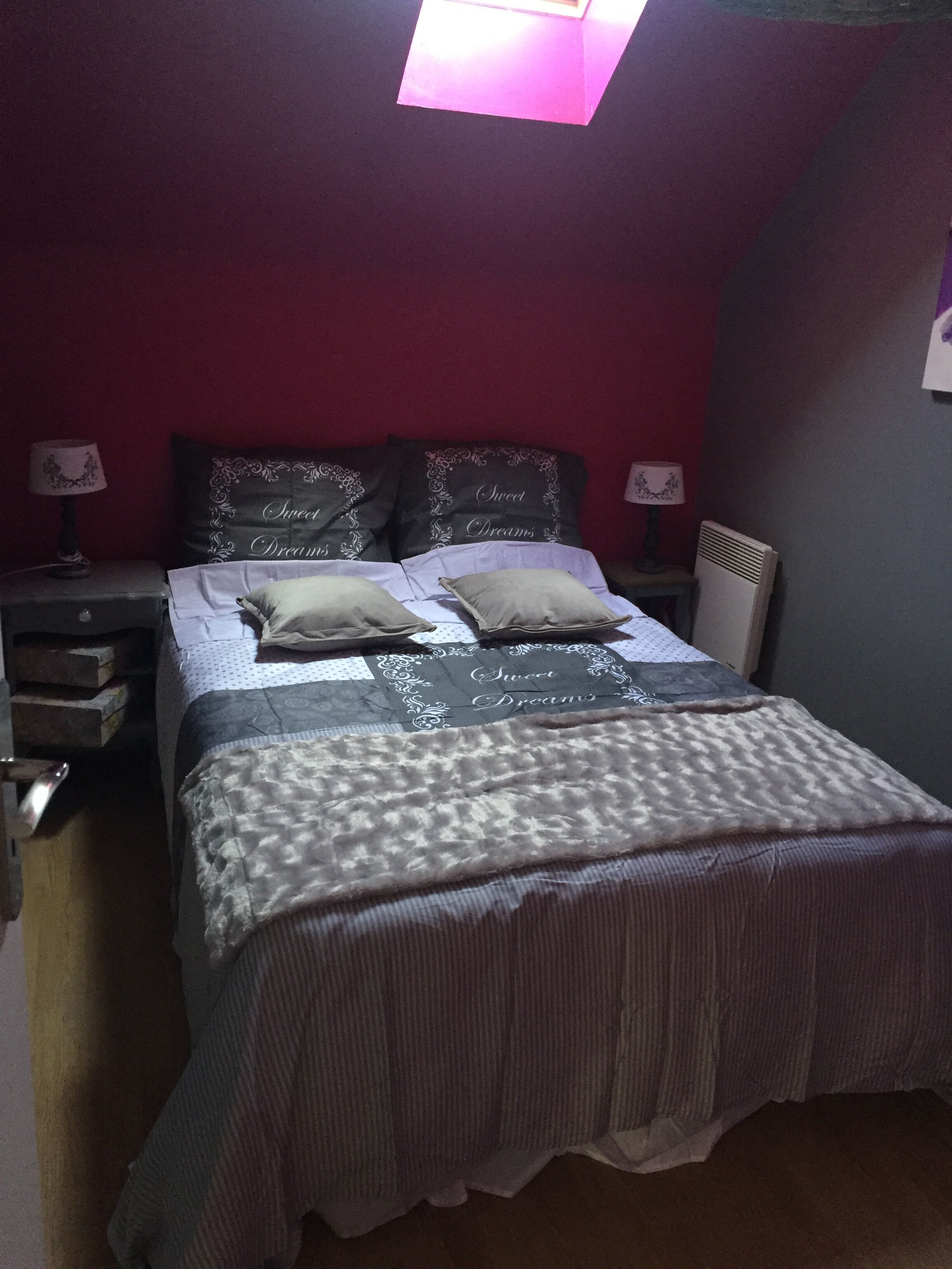 Ein Schlafzimmer mit einem Bett, zwei Nachttischen, einer Lampe und einem Kopfteil.