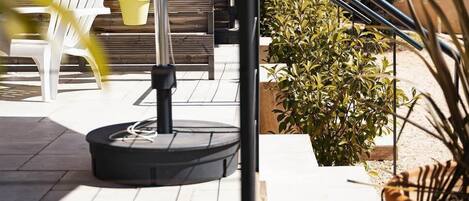 An outdoor patio area with a round table, chairs, and umbrellas.