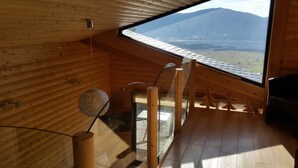 A wooden interior with a large skylight, a hanging light fixture, and a view of a mountain. - CERF apartment in new chalet with view of Matemale lake 12 beds (Les Angles)
