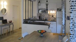 A modern kitchen with a central island, a dining area with a table and chairs, and a small kitchenette. - 3P RDJ air-conditioned apartment in residence with swimming pool and tennis court in St Aygulf (Unknown)