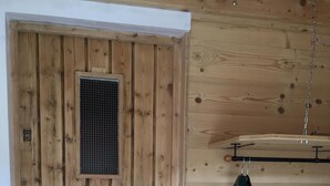 A wooden door with a vent, a metal handle, and a small electronic device on the wall. - CHALET SABOT OF STANDING VENUS AT THE FOOT OF TRACKS (Fontcouverte-la-Toussuire)