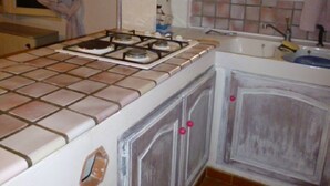 A kitchen with a stove, cabinets, and a window. - CARQUEIRANNE APARTMENT WITH POOL 2MN BEACH (Carqueiranne)