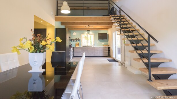 Ein modernes Interieur mit Treppe, Essbereich und Küche.