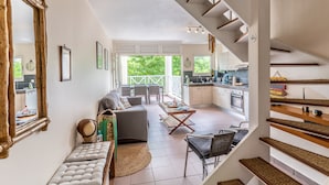 Un vaste espace de vie comprenant un canapé, une table basse et donnant sur le balcon extérieur.