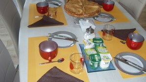 Ein Esstisch ist gedeckt mit Tellern, Besteck, Servietten und einem Kuchen.