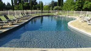 Une piscine aux eaux cristallines, entourée de chaises longues.