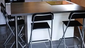 Een moderne keuken met een centraal kookeiland, twee barkrukken, een inbouwoven en een spoelbak.