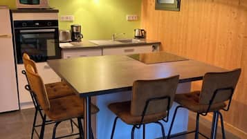 Une cuisine compacte dotée d’un îlot central, d’un four à micro-ondes, d’une cuisinière et d’un évier.