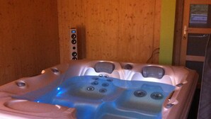 Een jacuzzi met meerdere jets, een bedieningspaneel en een houten wand.