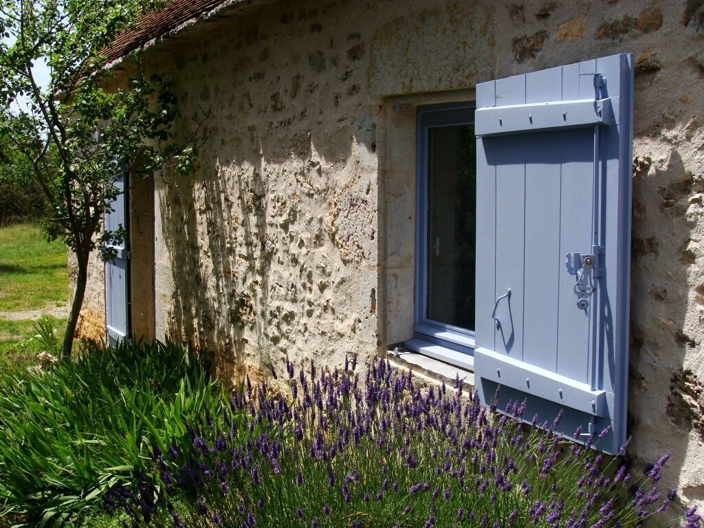 Un bâtiment rustique en pierre, doté d’une fenêtre et d’une porte.