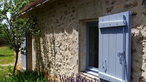 Een landelijk stenen gebouw met een raam en een deur.