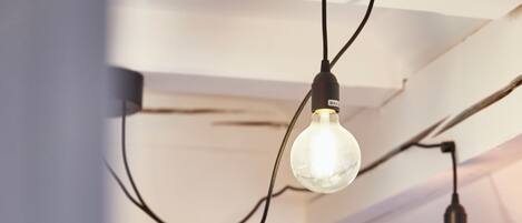 Une cuisine moderne avec un mur de fond en briques blanches et des luminaires suspendus.