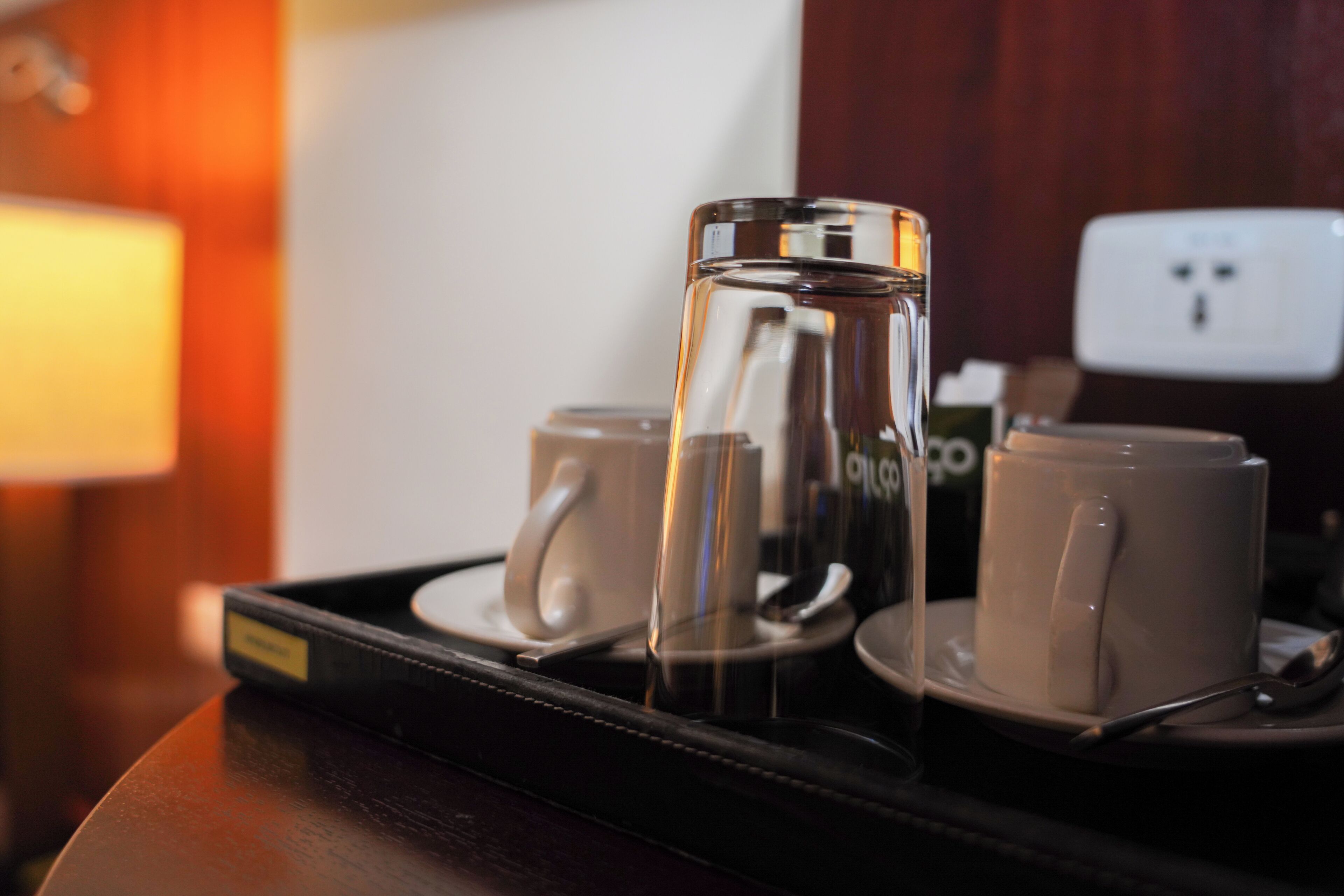A tray with a coffee pot and two mugs on a wooden surface.