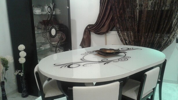 Una mesa de comedor con un centro de mesa decorativo, rodeada de sillas.