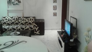 Una sala de estar con sofá, televisor y una mesa de centro.
