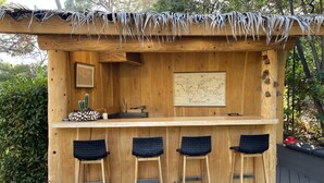 Un bar en bois avec un toit de chaume, une carte du monde et des décorations à thème de cactus.