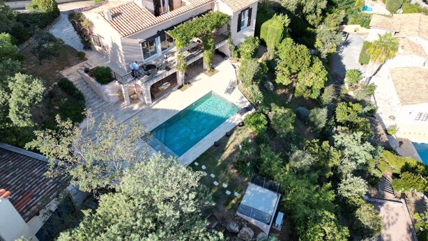 A large house with a swimming pool surrounded by lush greenery. - Beautiful 4 * villa with private heated pool, sea view, 5 minutes from the beach (Fréjus)