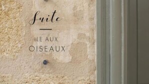 A wall with the text "Suite Ile Aux Oiseaux" pinned to it.