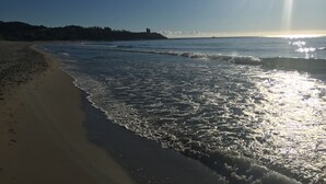 A beach with waves, a clear sky, and a distant shoreline. - Superb architect villa (TERTENIA DI MARINA)