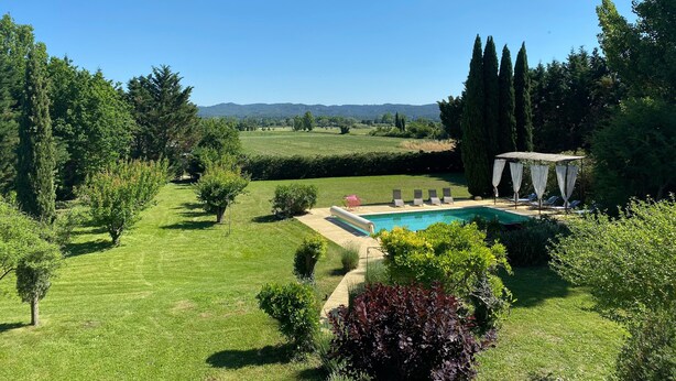 A well-maintained garden with a swimming pool, surrounded by neatly trimmed grass and various shrubs. - Magnificent in the heart of Provence (Maillane)