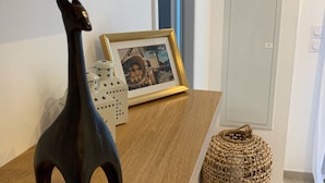 A wooden table with a dark figurine, a framed photo, and a woven basket. - New apartment, 4 people, ground floor, town center. (Cassis)