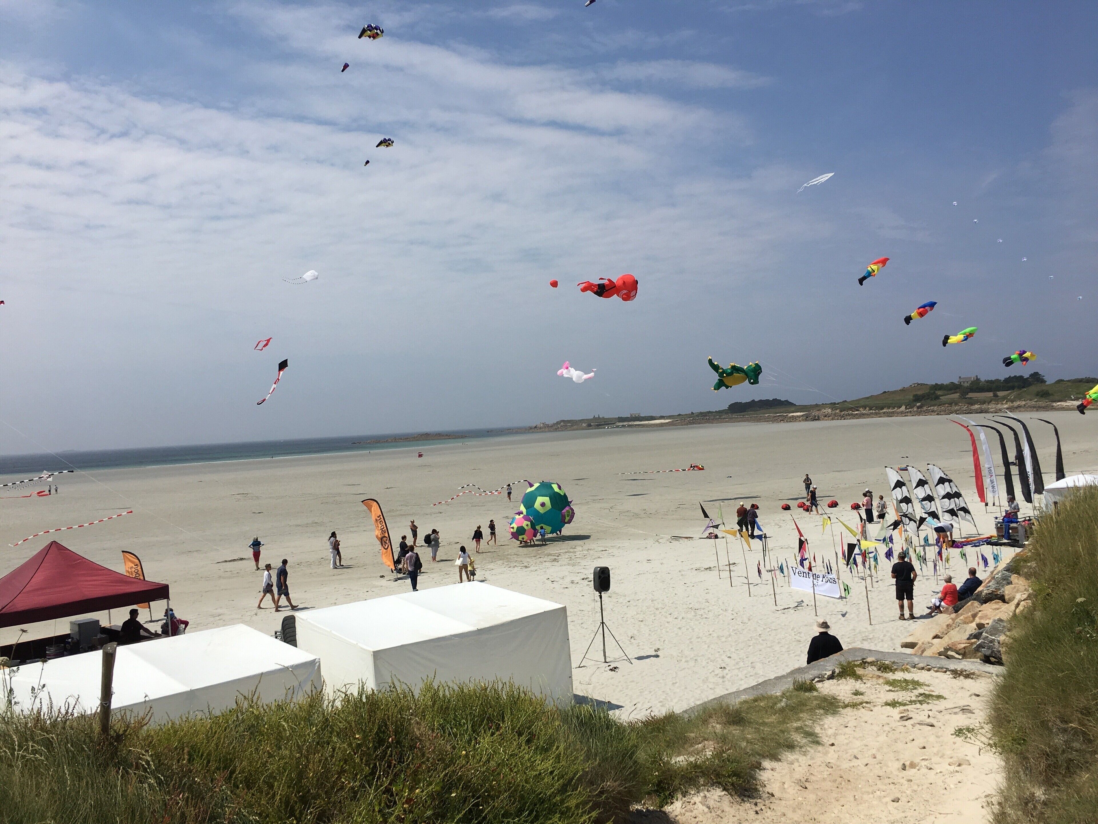 Una playa con tiendas de campaña y gente.
