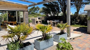 A patio area with a pergola, outdoor seating, and potted plants. - CHARMING 4 **** in quiet, fully renovated, near the sea - PMR (Santec)