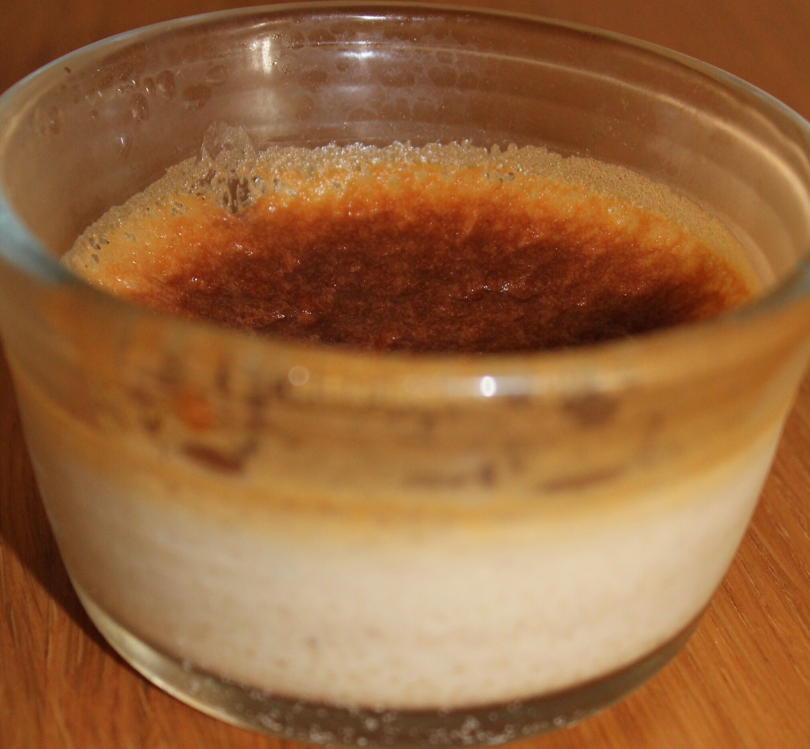 A clear glass bowl containing a layered mixture of brown and white substances.