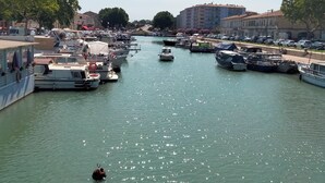 A marina with boats docked along the water, surrounded by buildings and trees. - Large villa with pool in Provence near Les Baux de Provence, Nimes (Beaucaire)