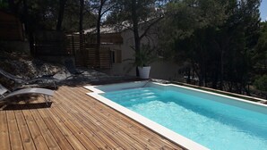 A wooden deck with a swimming pool, lounge chairs, and a potted plant. - Large villa with pool in Provence near Les Baux de Provence, Nimes (Beaucaire)