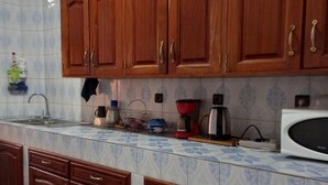 A kitchen with wooden cabinets, a sink, and various appliances.
