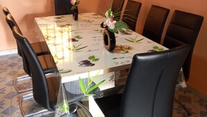 A dining area with a rectangular table, six black chairs, and two flower arrangements.