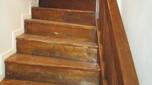 Eine Holzt Treppe mit einem Holzgeländer, das zu einer Ziegelwand führt.