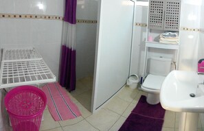 A small, clean bathroom with a toilet, sink, and a drying rack. - the feet in water (le francois)