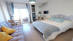 A bedroom with a bed, a sofa, a TV, and a wardrobe. - SEA VIEW STUDIO (Benalmádena)
