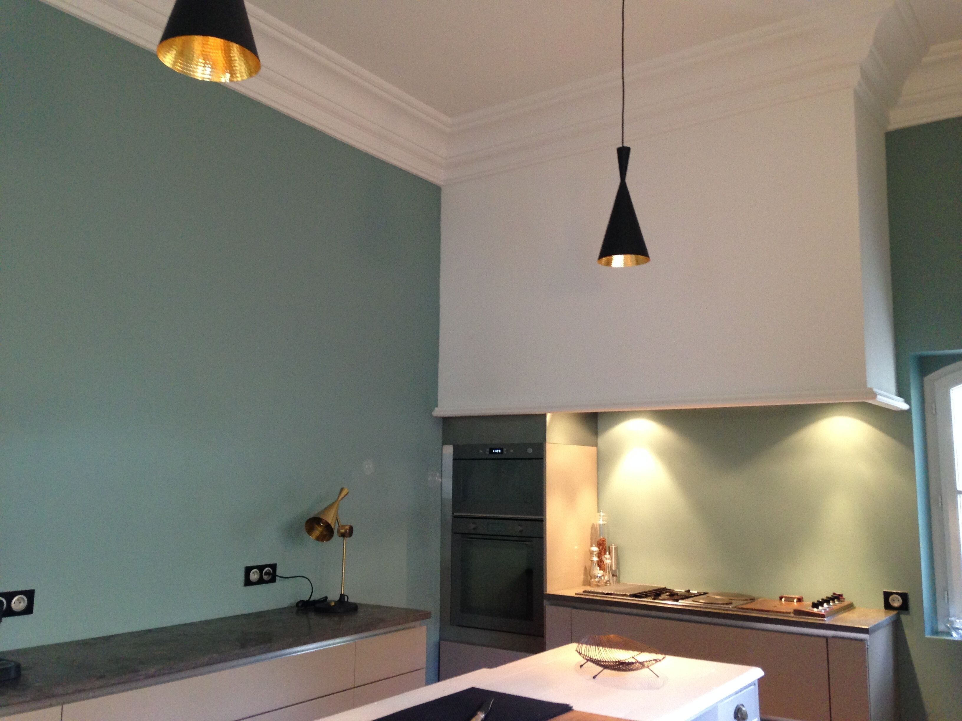 A kitchen with a modern design, featuring a countertop, a stove, and a sink.