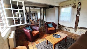 Un salon chaleureux avec deux fauteuils en cuir, une table basse en bois et un tapis à motifs.