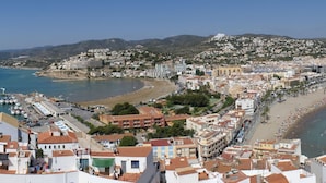 Paisagem costeira com marina, praia e edifícios residenciais.